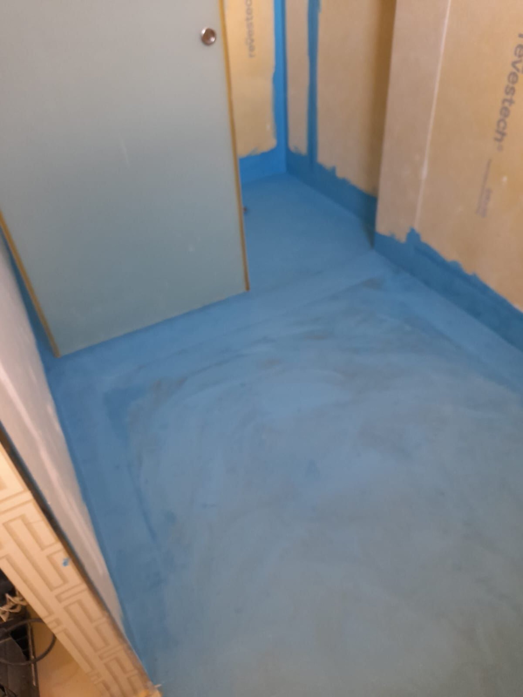 Blått membranlag på badegulv før flislegging