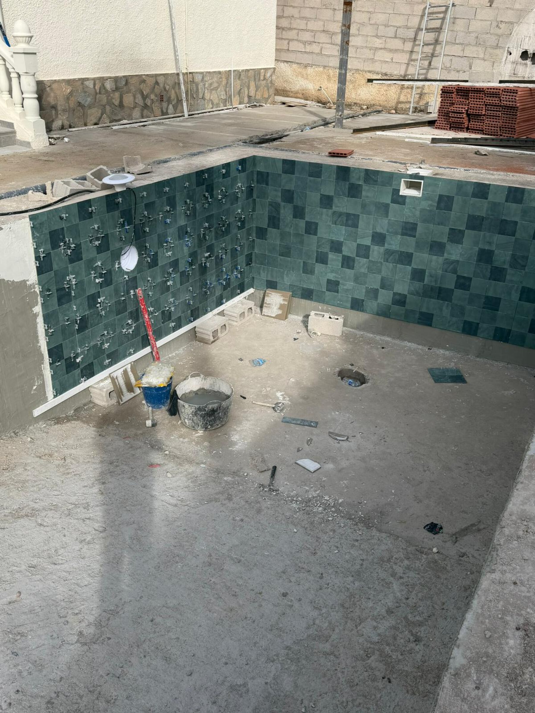 Grønn glassmosaikk legges på basseng-vegg